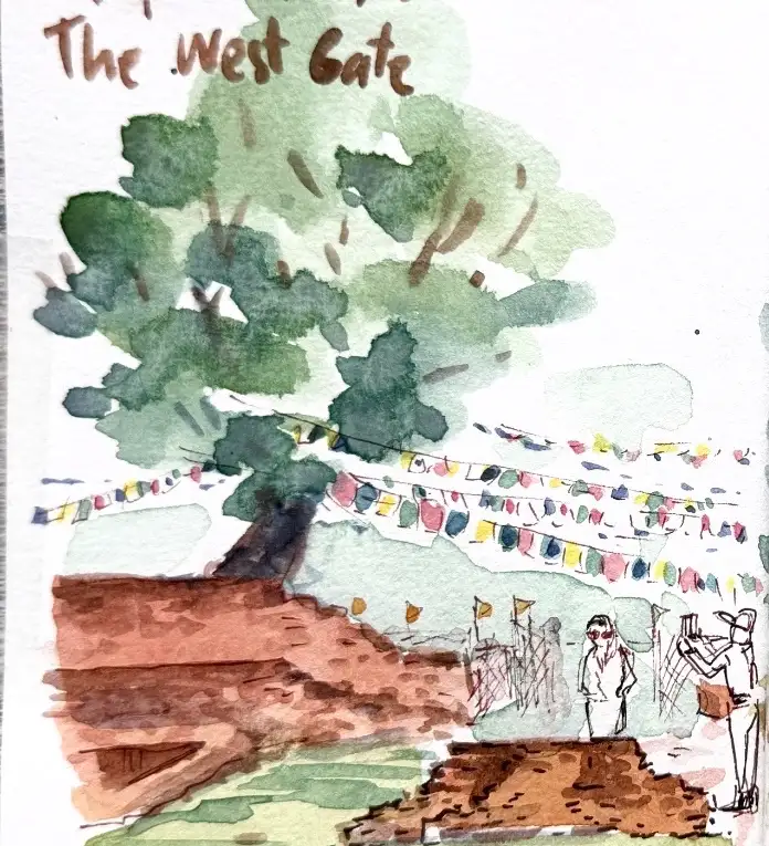 The left half: a great soft green tree over a brick ruin, prayer flags strung across in front of it, two figures standing on the mound
