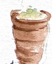 A clay cup of lassi, thick and pale, with a lemon slice on the rim